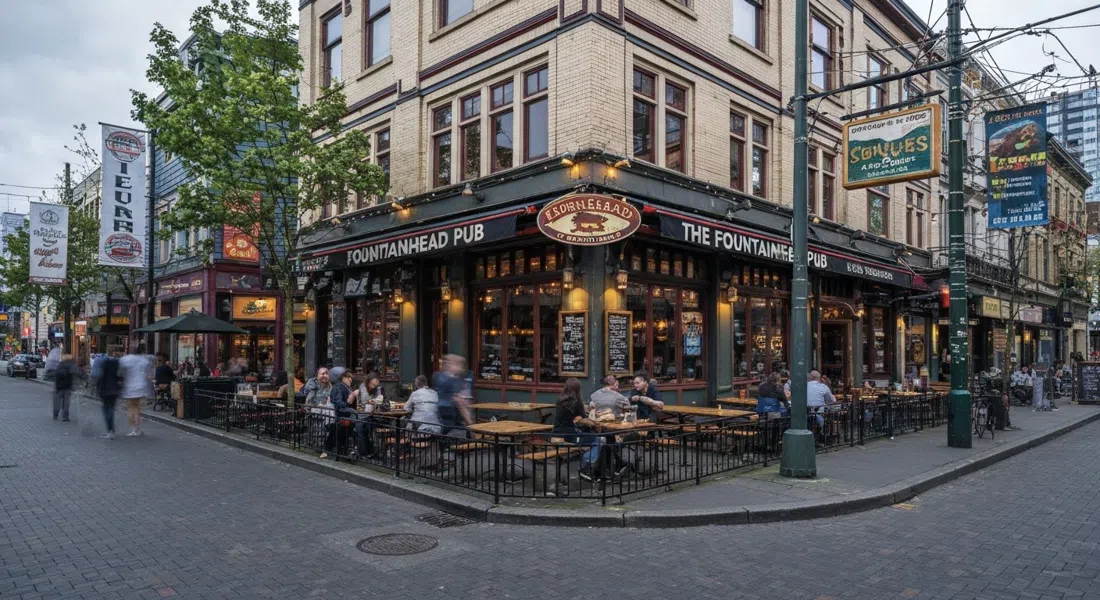 The Fountainhead Pub en Davie Street, grandes mesas en la terraza bajo la luz del atardecer, con la fachada del pub de esquina y la energía del Village arcoíris
